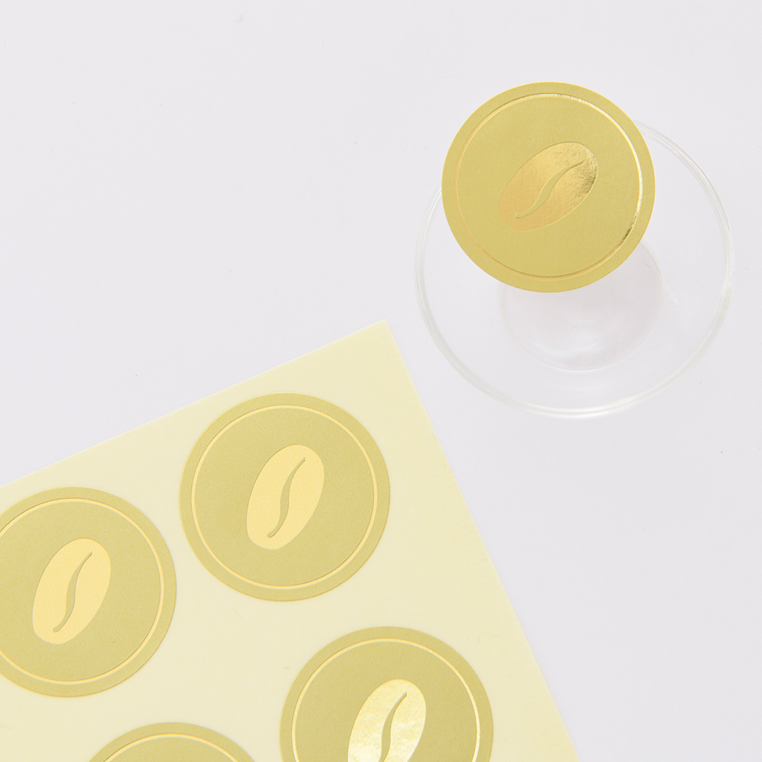 シールに箔押しされたメタリック金箔の豆イラストが、光を受けて輝いている